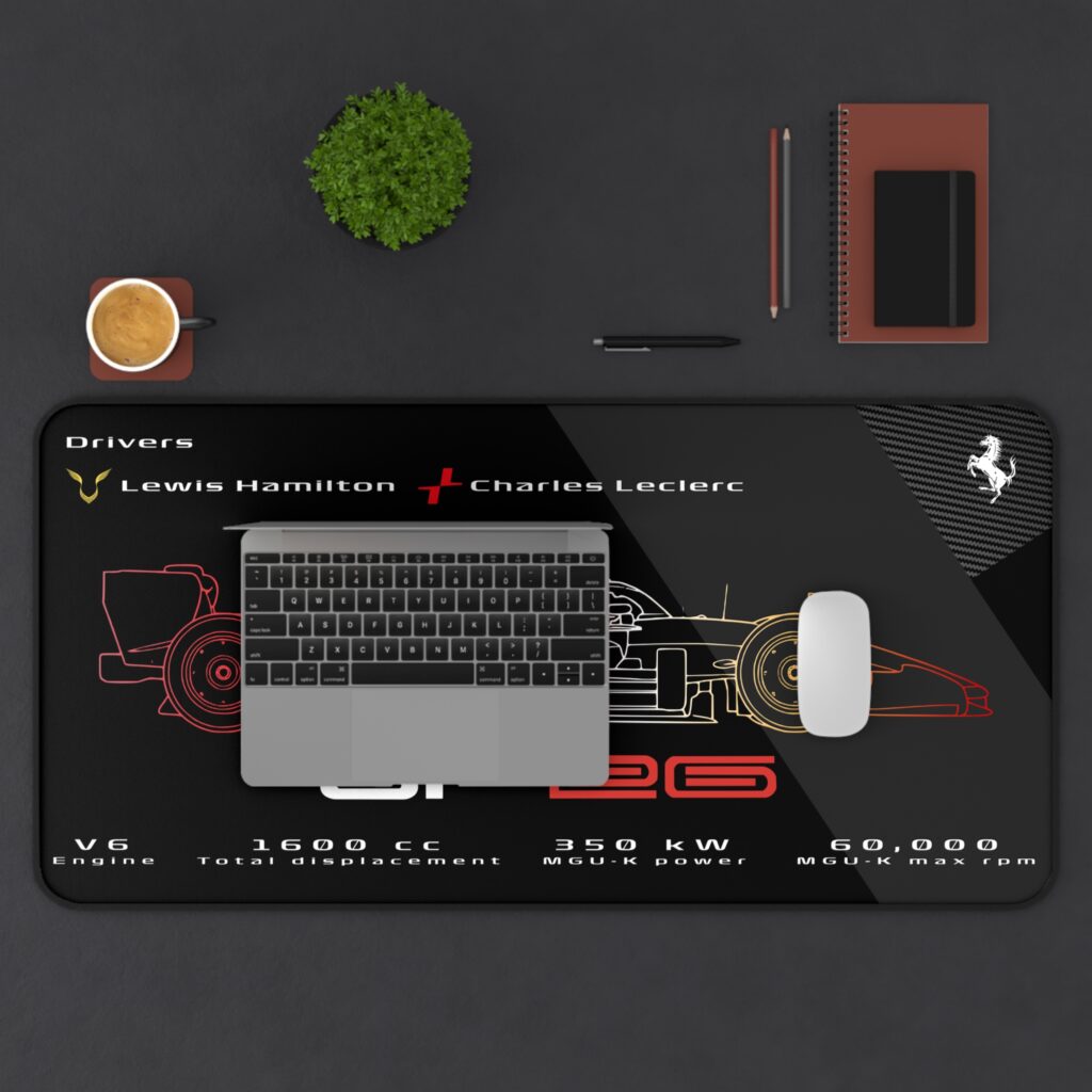 Black SF-26 technical spec desk mat with red and yellow gradient line art featuring Hamilton Leclerc and 1600 cc V6 engine data