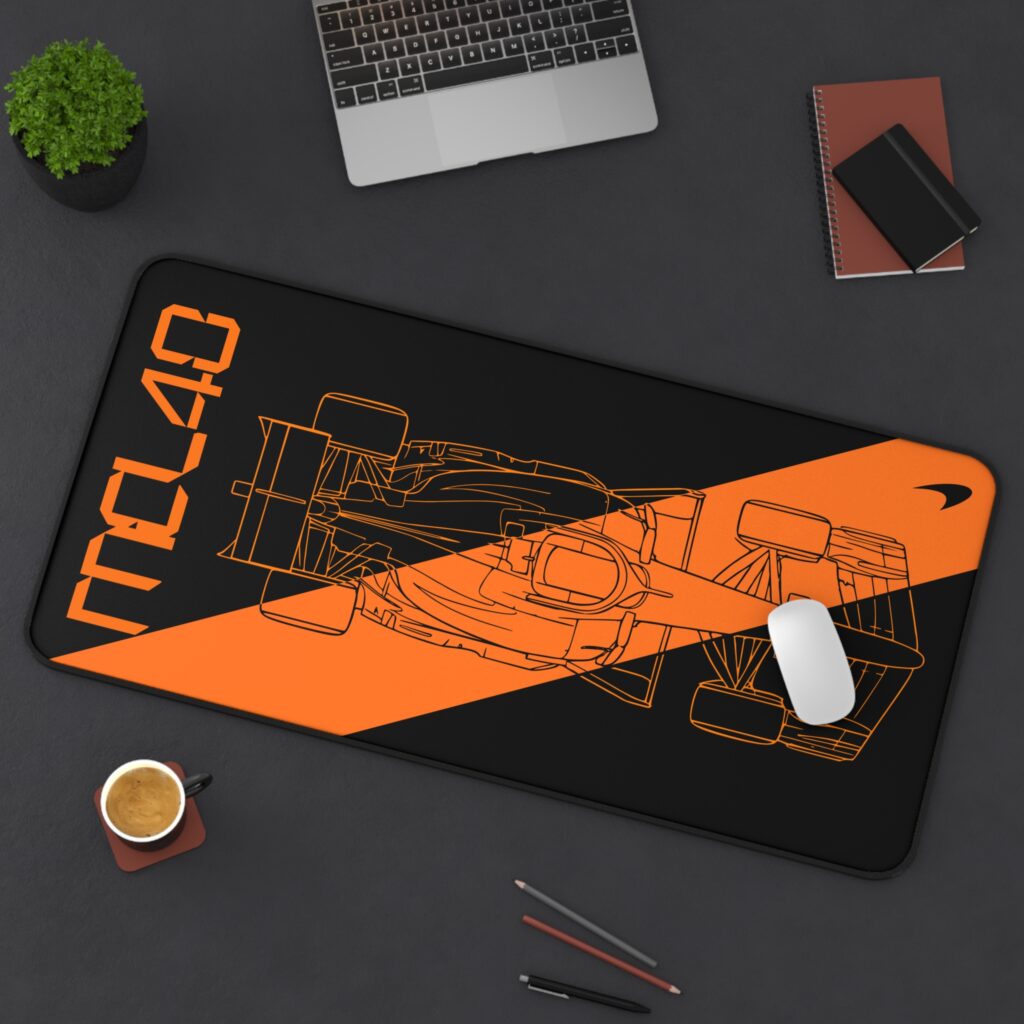 Stealth black MCL40 2026 F1 car blueprint desk mat with papaya orange lines